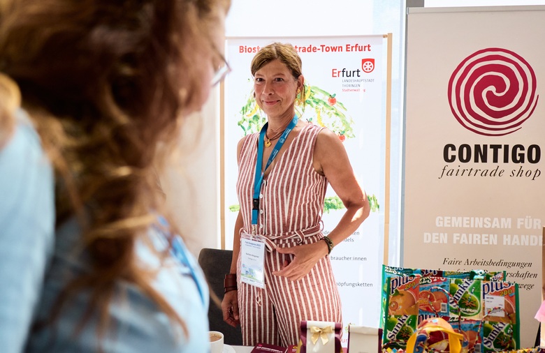 Eine Frau steht hinter einem Informationsstand der Fairtrade Stadt Erfurt